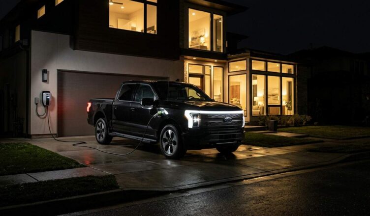 photorealistic image of a Ford F-150 Lightning parked in a suburban driveway powering a modern house during a nighttime power outage, interior house lights glowing while neighborhood is dark, charging cable connected to home system, dramatic contrast lighting, editorial automotive photography, hyperrealistic, shot on Canon EOS R5, --ar 16:9