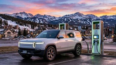 A 2026 electric SUV charging at a modern public station in a scenic Colorado mountain setting, symbolizing state-specific EV benefits