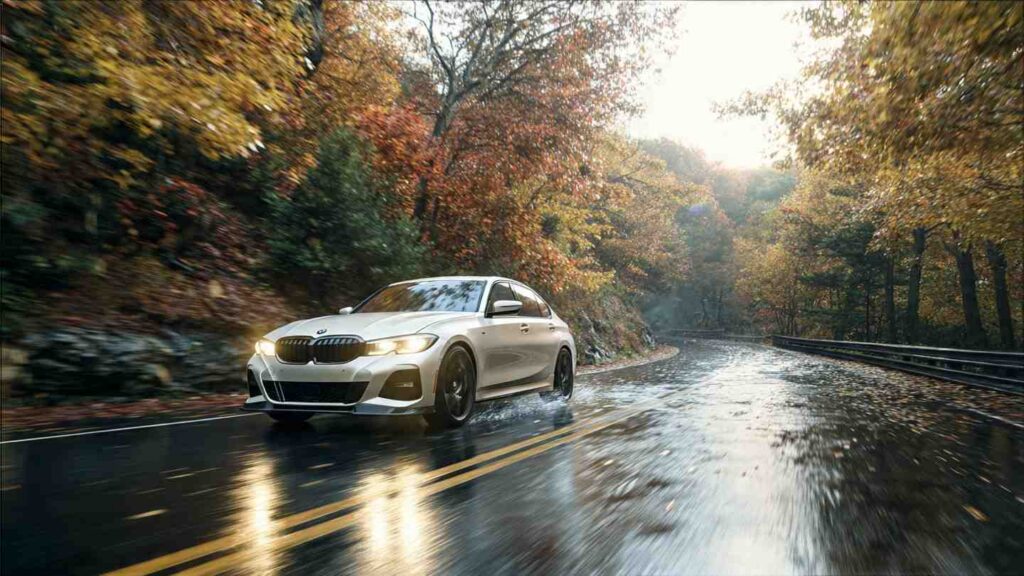 2026 BMW 330i driving on a rain-wet mountain road in autumn