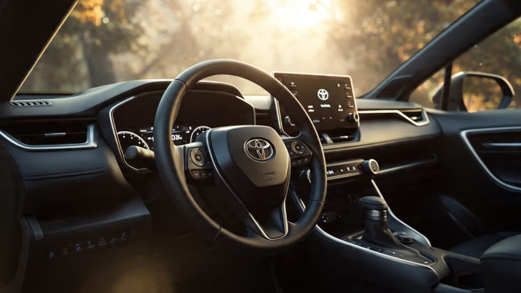 Close-up of a 2026 Toyota RAV4 infotainment screen displaying hybrid energy flow and a digital odometer reading 12 miles.
